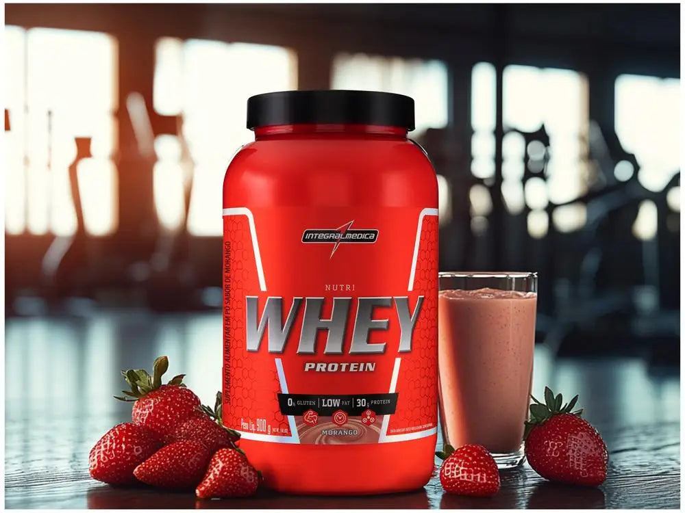 Hypercaloric Whey Protein Powder 900g from Integralmedica with strawberries and smoothie in gym setting.